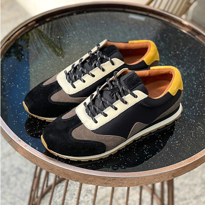 Dauerhafte athletischer Sport-Schuhe gleiten nicht weiches ledernes Tennis-Schuh-Schwarzes